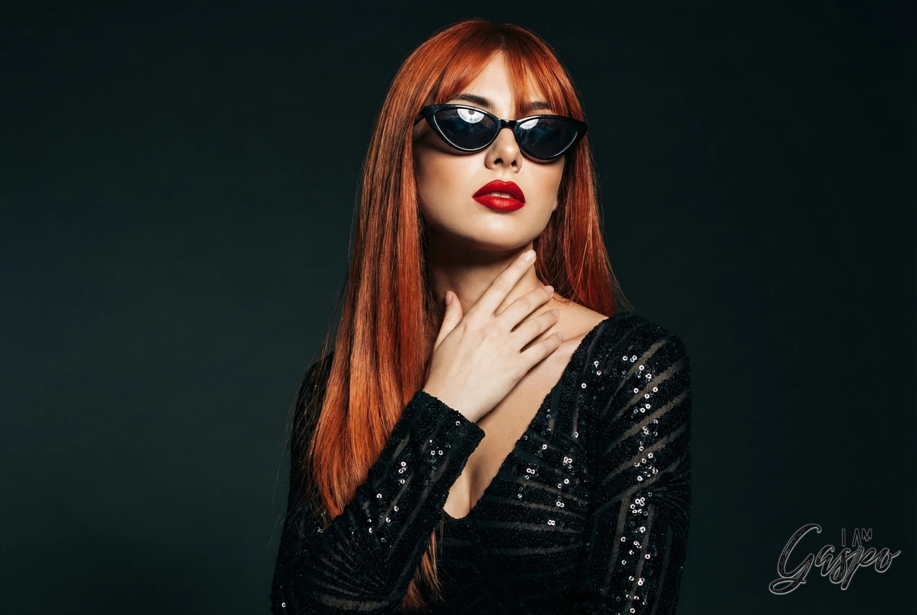 Fashion portrait of a red-haired woman wearing sunglasses